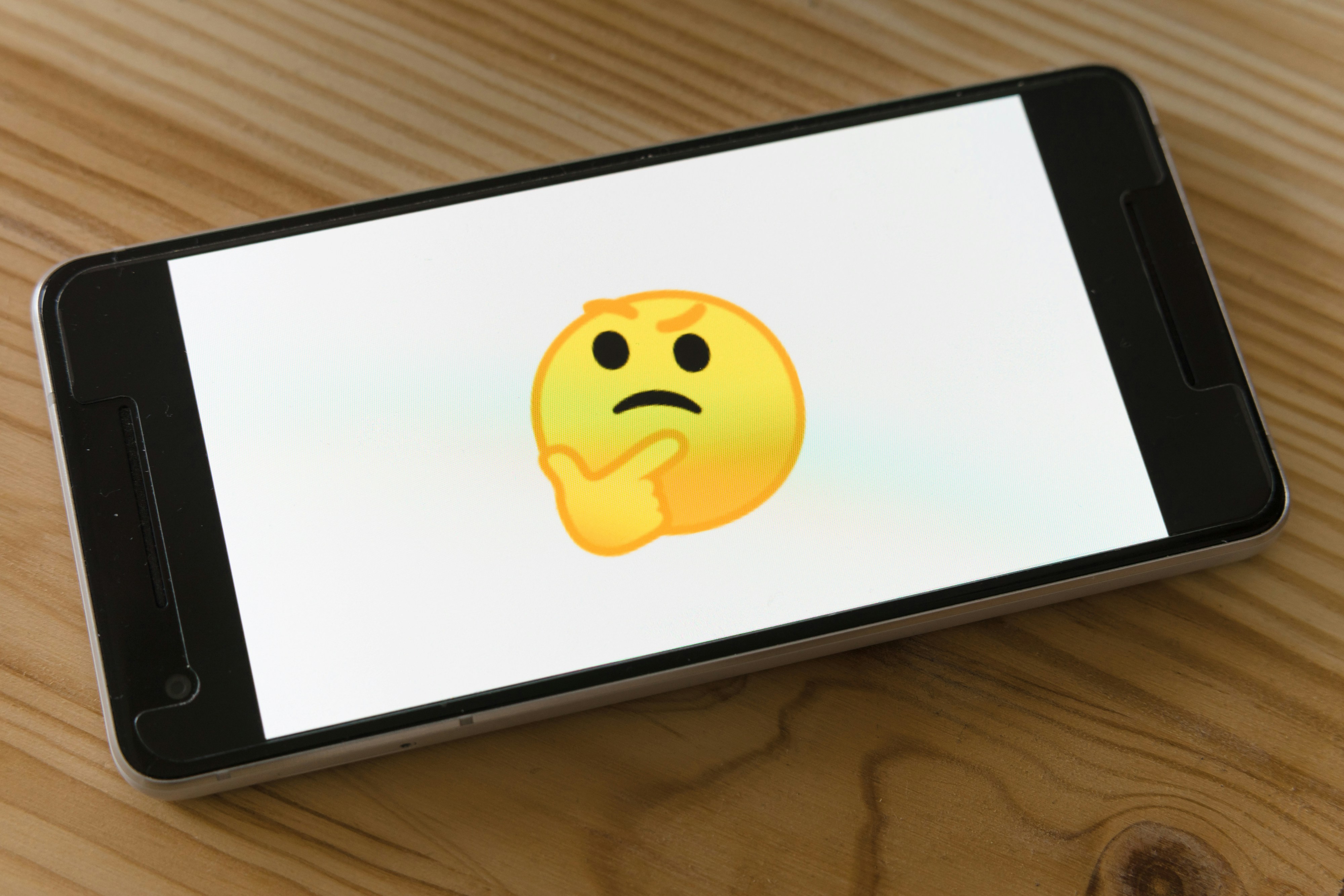 A picture of a phone with a thinking emoji